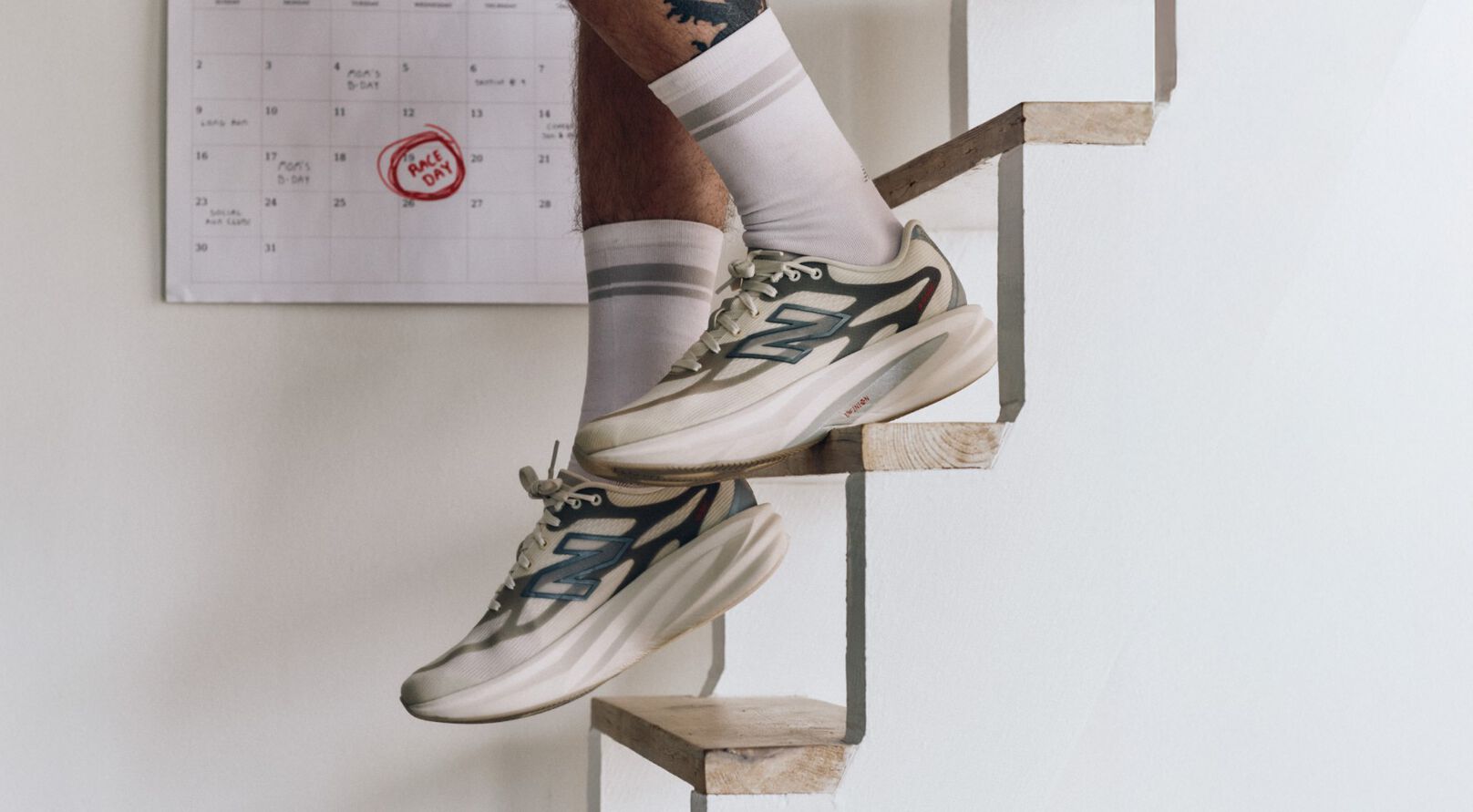 Close up of someone descending stairs in New Balance running shoes.